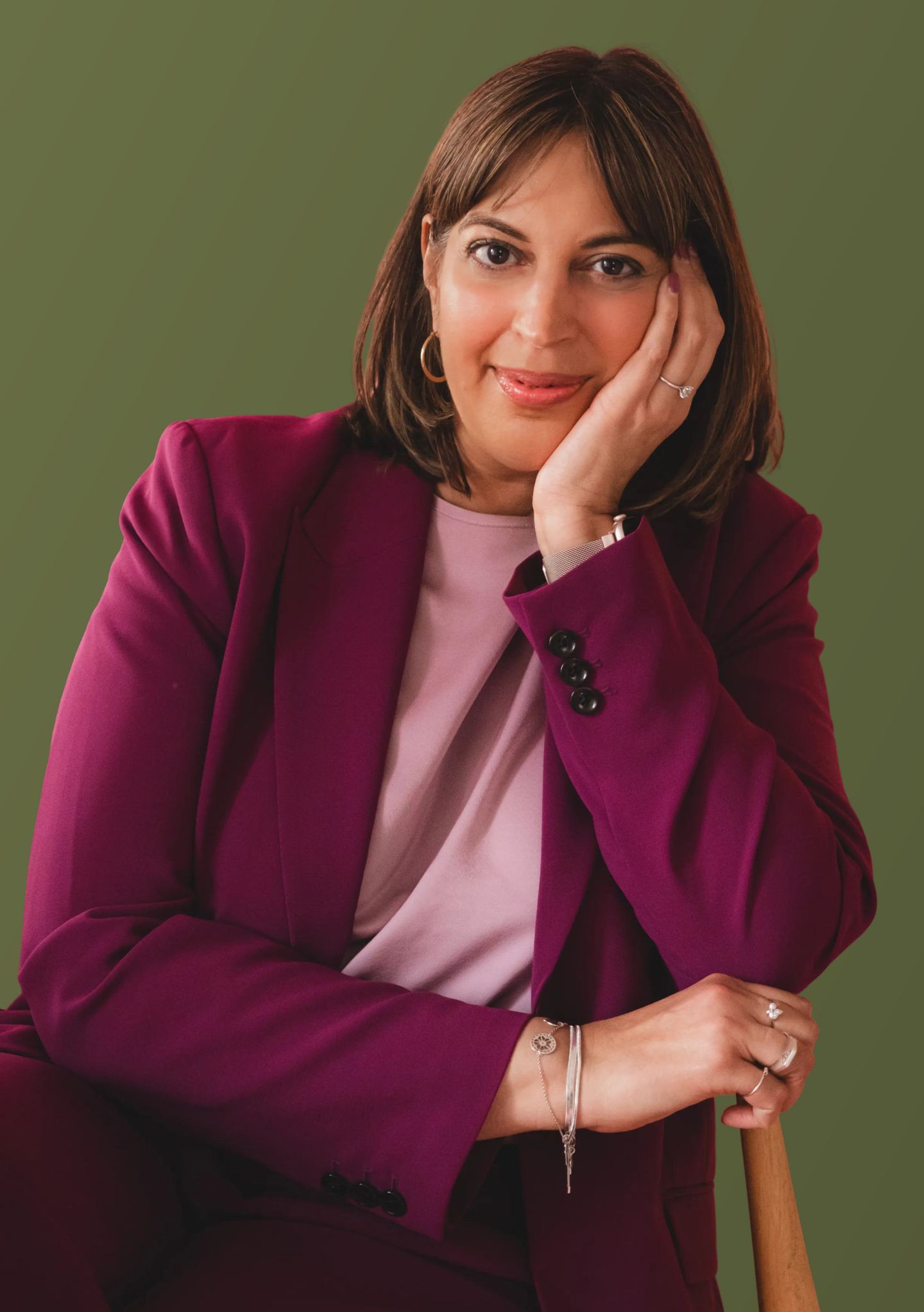 Vesna Antwan resting her chin on her hand, wearing a plum suit
